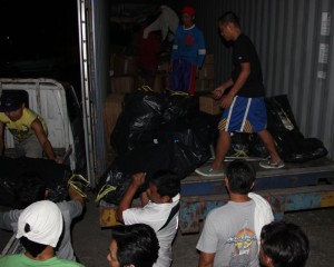 Volunteers from Bukas Palad Foundation unload container of aid at Cebu port. 