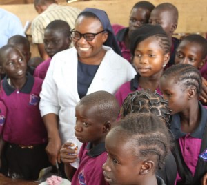 Sr Anne Falola, OLA with children of Durumi IDP Camp in Abuja cutting a cake with marked the opening of the Maria Centre. 