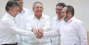 President Santos (left) and FARC leader “Timochenko” shake hands after meeting facilitated by Raul Castro (centre)